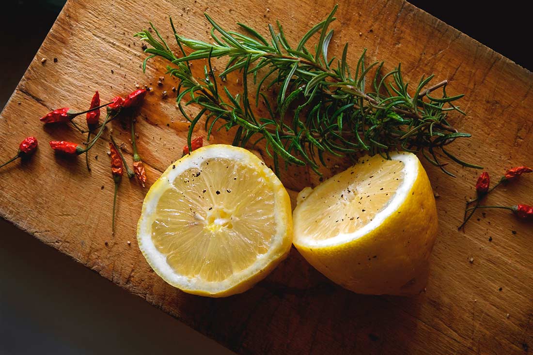 limão e pimenta sobre uma tábua que juntos formam o tempero lemon pepper