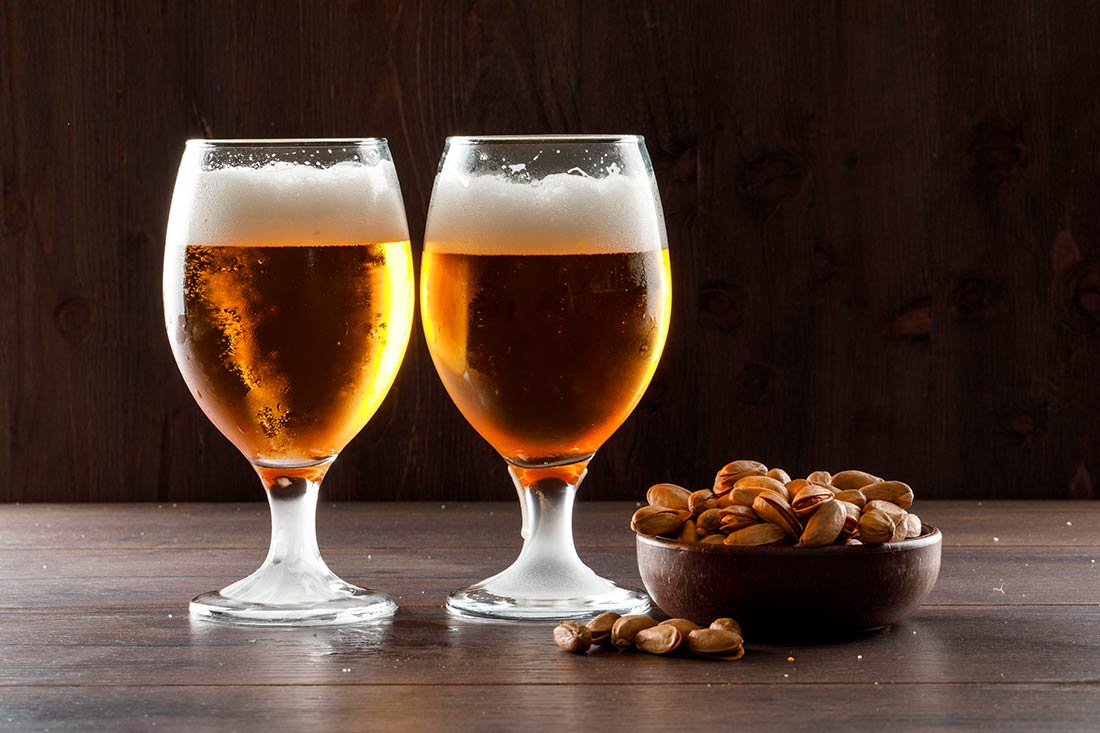 imagem de duas taças pokal cheias de cerveja, sobre uma mesa
